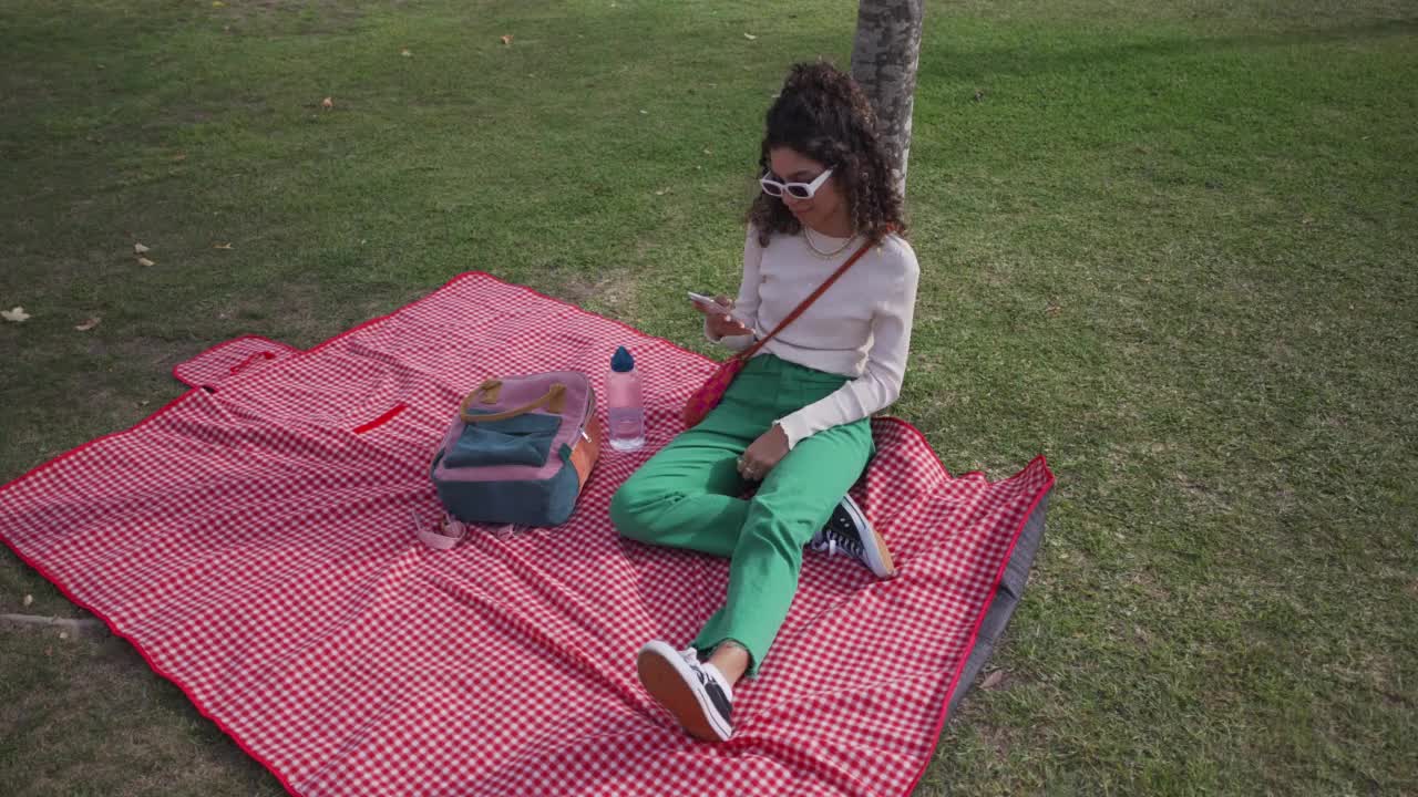 少女在公共广场上使用智能手机视频下载