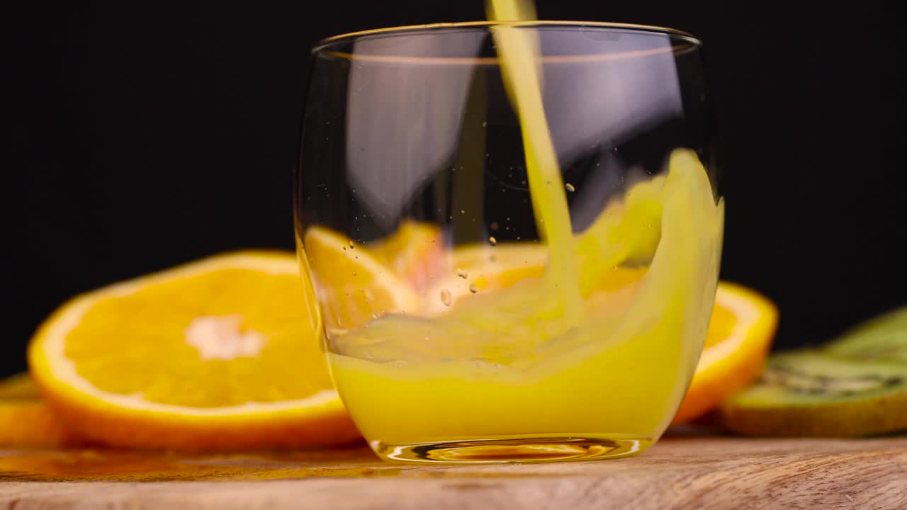 把橙汁倒进玻璃杯里视频下载
