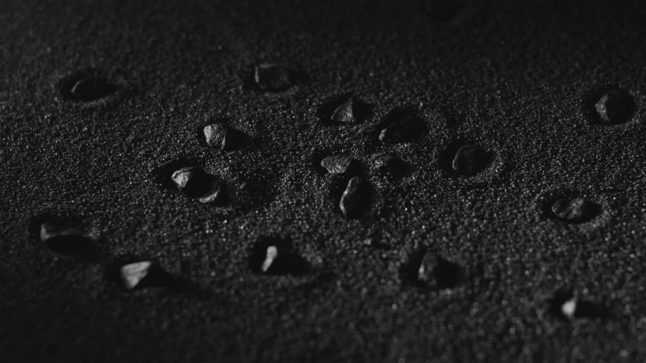 黑土壤背景。黑色泥土覆盖表面，石头。抽象的背景。颗粒状粉末，火山尘埃视频素材