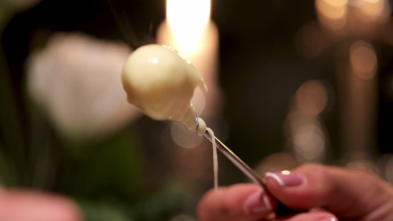 一个男人和一个女人的手蘸圣女果融化的fundu奶酪视频素材