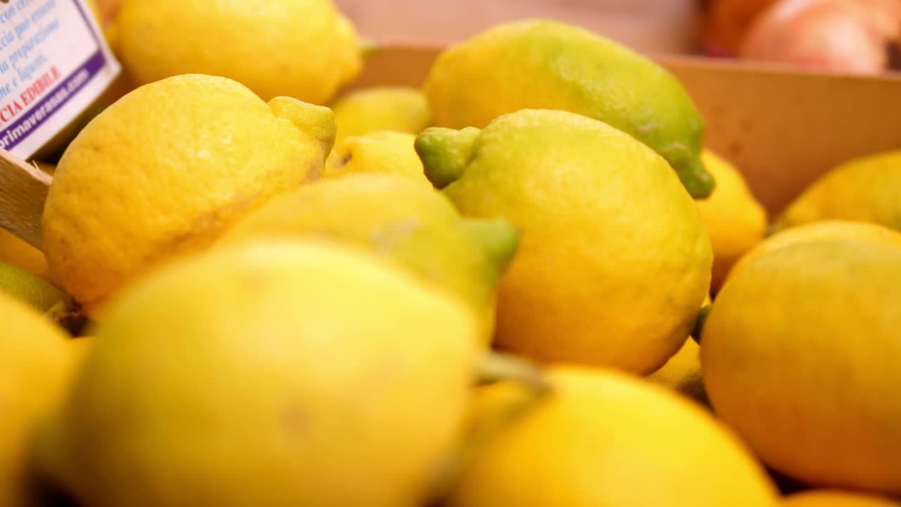 在水果和蔬菜市场的摊位上，装满柠檬的容器视频下载