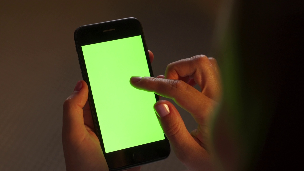 年轻女子拿着手机。带有绿色屏幕的模拟手机视频下载