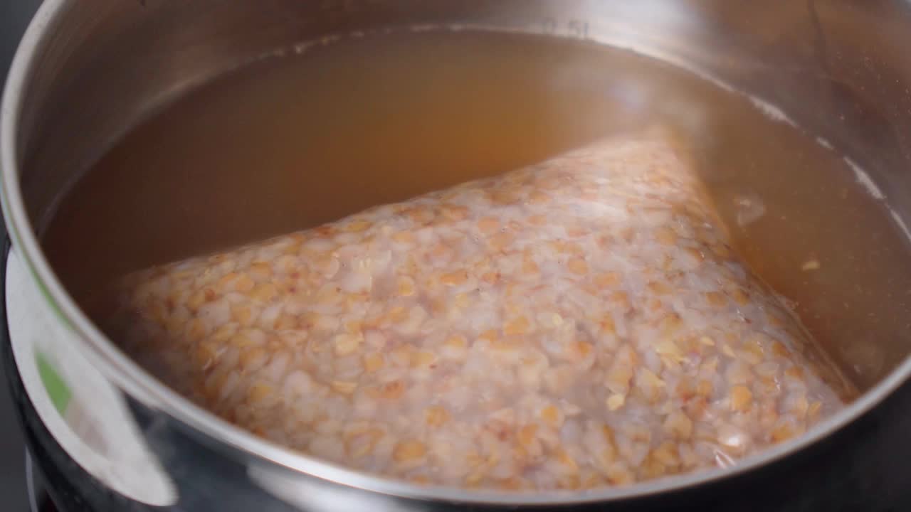 烧开的水倒入炖锅。烹饪荞麦燕麦。有选择性的重点。健康的食物视频素材