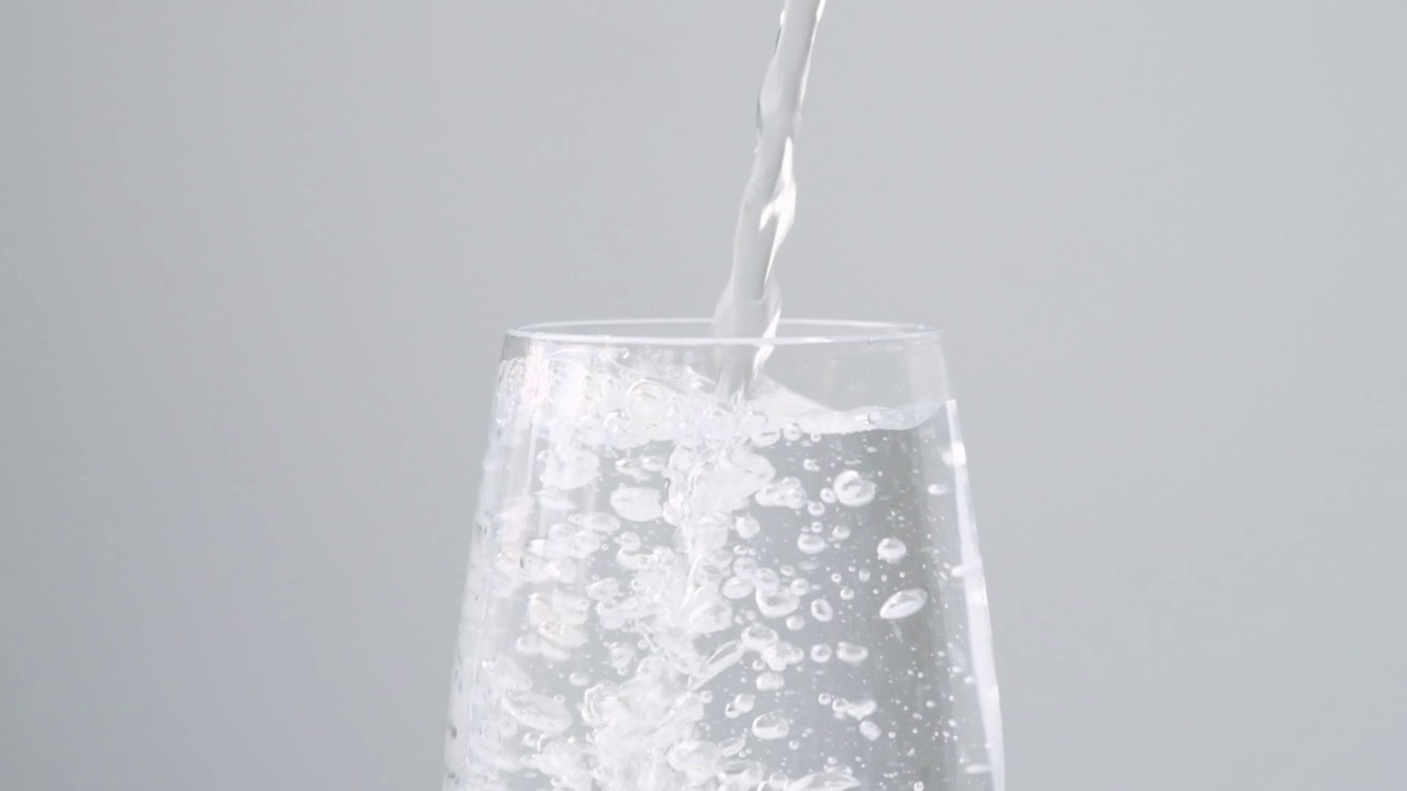 纯净水倒进玻璃特写。超级慢动作。清澈新鲜的饮用水灌装杯视频素材