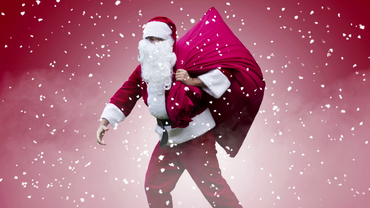 圣诞老人在红色背景的雪地里行走的电影图片视频下载