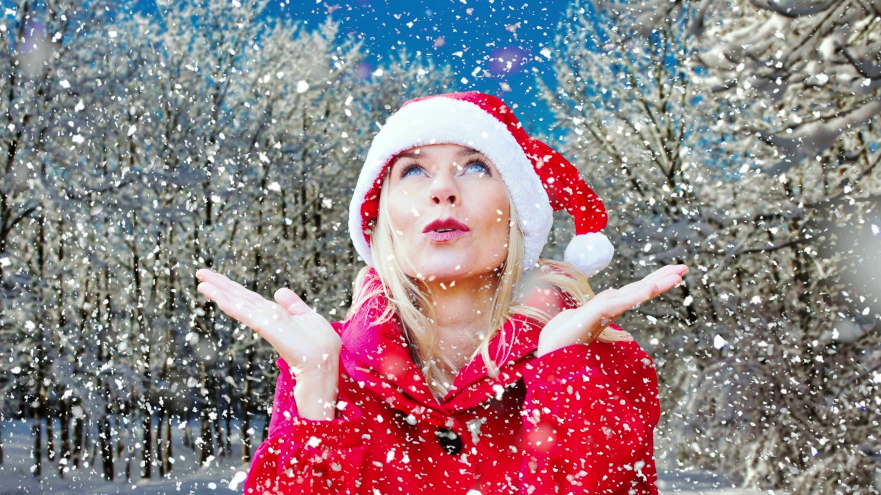 金发女人打扮成圣诞老人在雪林的户外电影视频下载