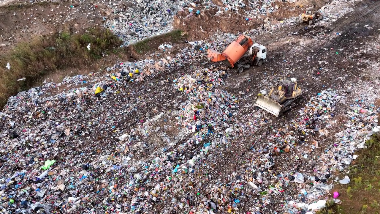 推土机在垃圾场与废旧塑料和聚乙烯。环境污染。视频素材