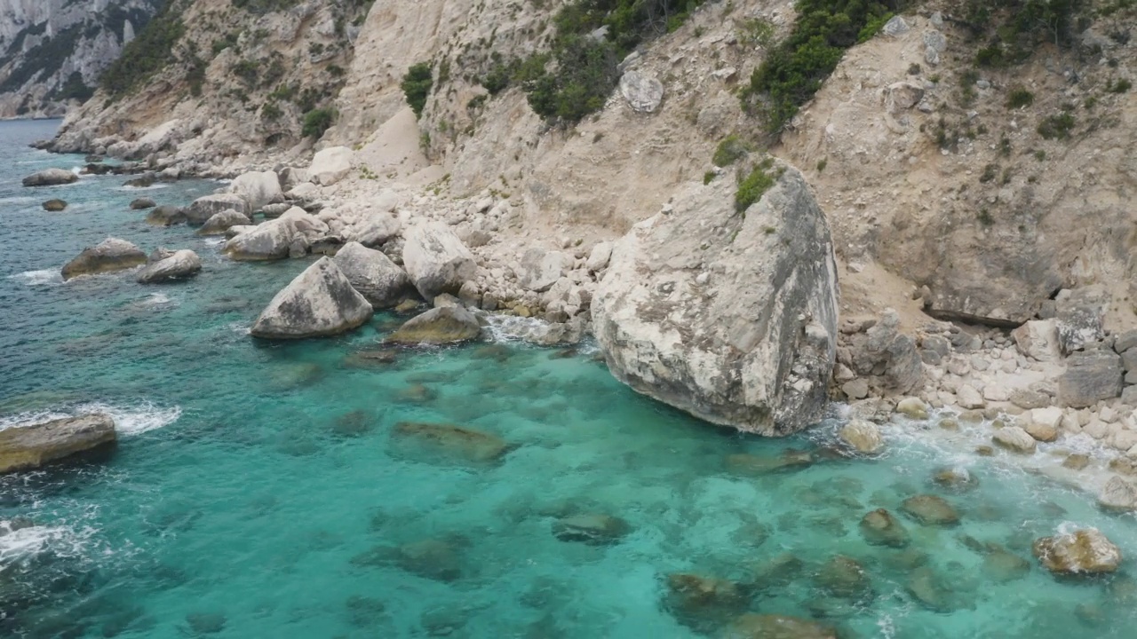 夏日海景鸟瞰图美丽的岩石海岸与李尔蓝绿松石水撒丁岛，意大利视频下载