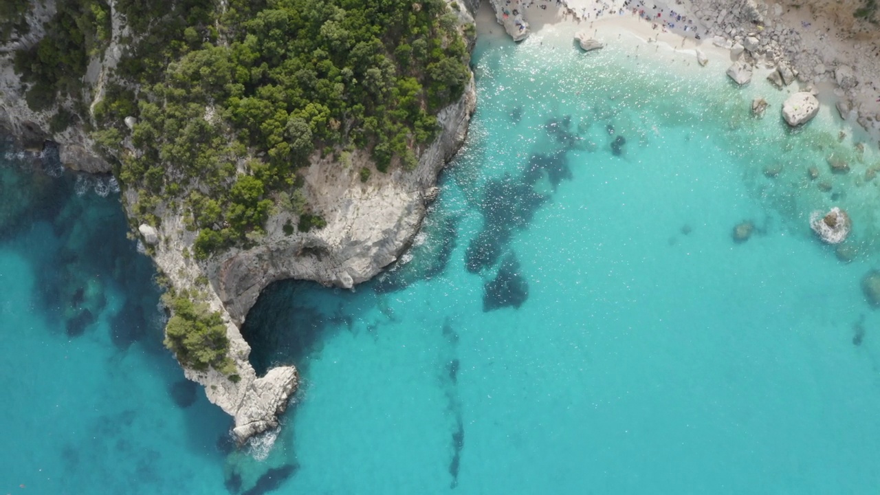 飞越海洞和碧蓝碧绿的水面俯瞰。cpncept旅行。夏日海景的鸟瞰图。意大利撒丁岛视频素材