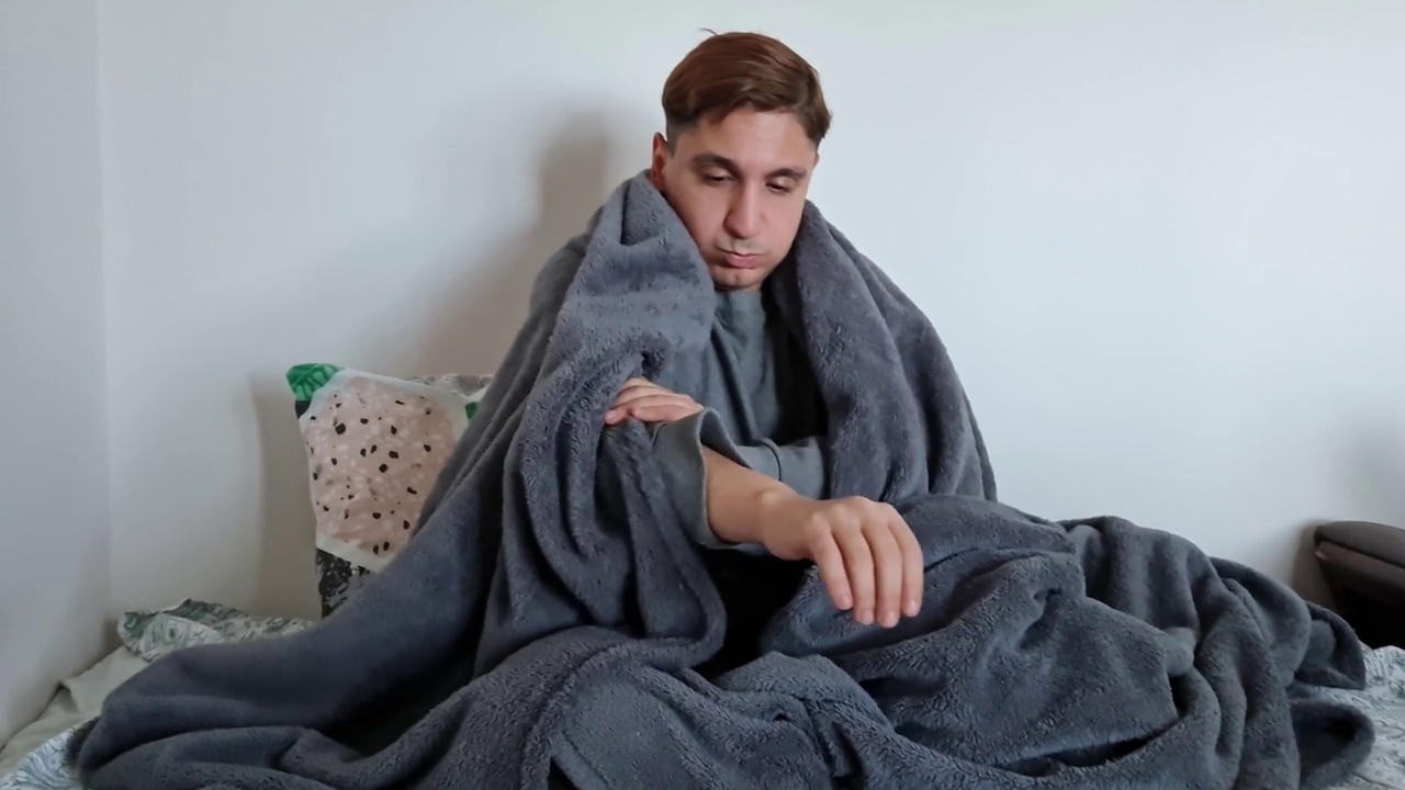 生病的年轻人发烧坐在床上视频素材