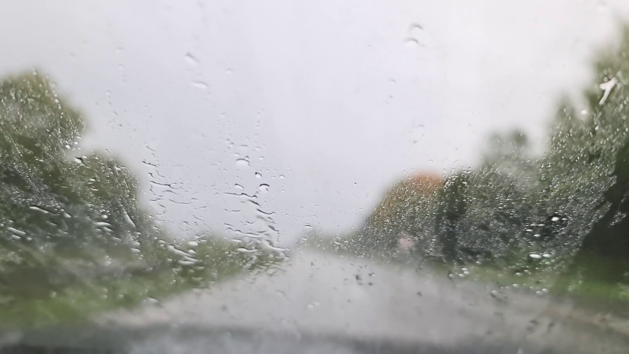 在大雨中开车时，从汽车挡风玻璃看到的景象。视频素材
