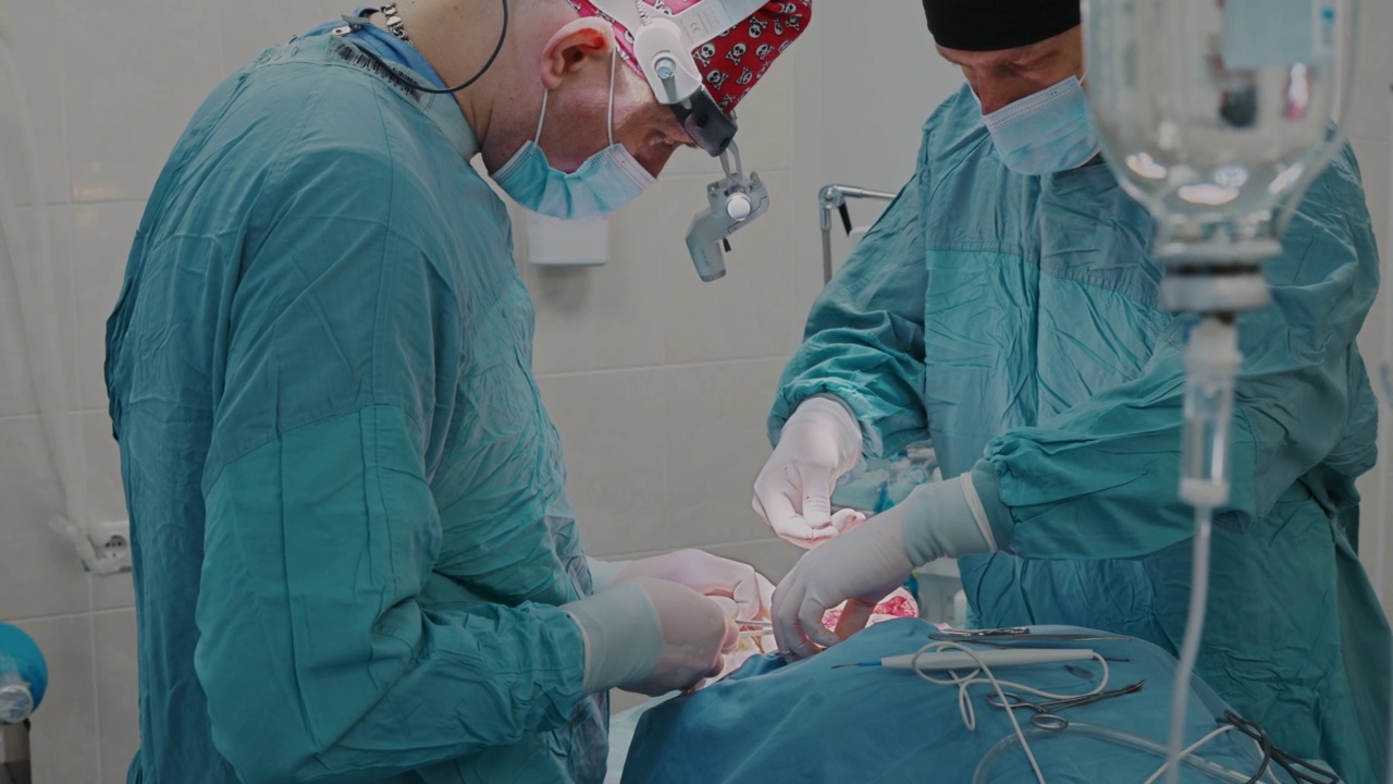 医疗队使用医用线对淋巴结进行手术，并用医用剪刀将多余的部分剪掉视频下载