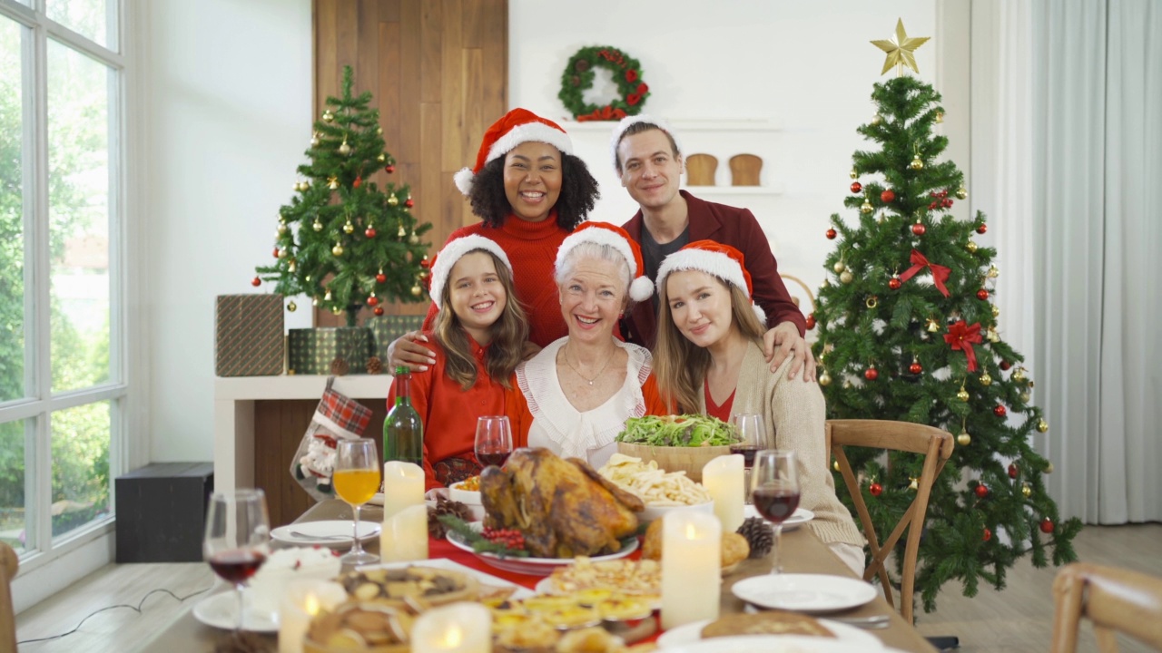 一个多民族的群体。白人和非裔美国黑人家庭的画像，妇女在圣诞夜的聚会上有一个庆祝晚餐在圣诞假期在家。人们的生活方式。感恩节视频下载