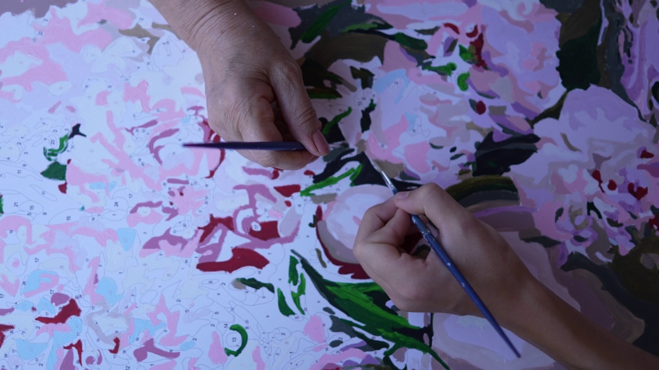 特写老年妇女和她的孙子在画布上绘画。视频下载