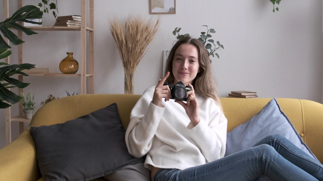 一个女人在家里用相机拍照的肖像。视频素材