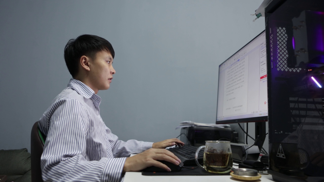 晚上，一名亚洲男子在电脑前工作——这是年轻人的生活方式视频下载