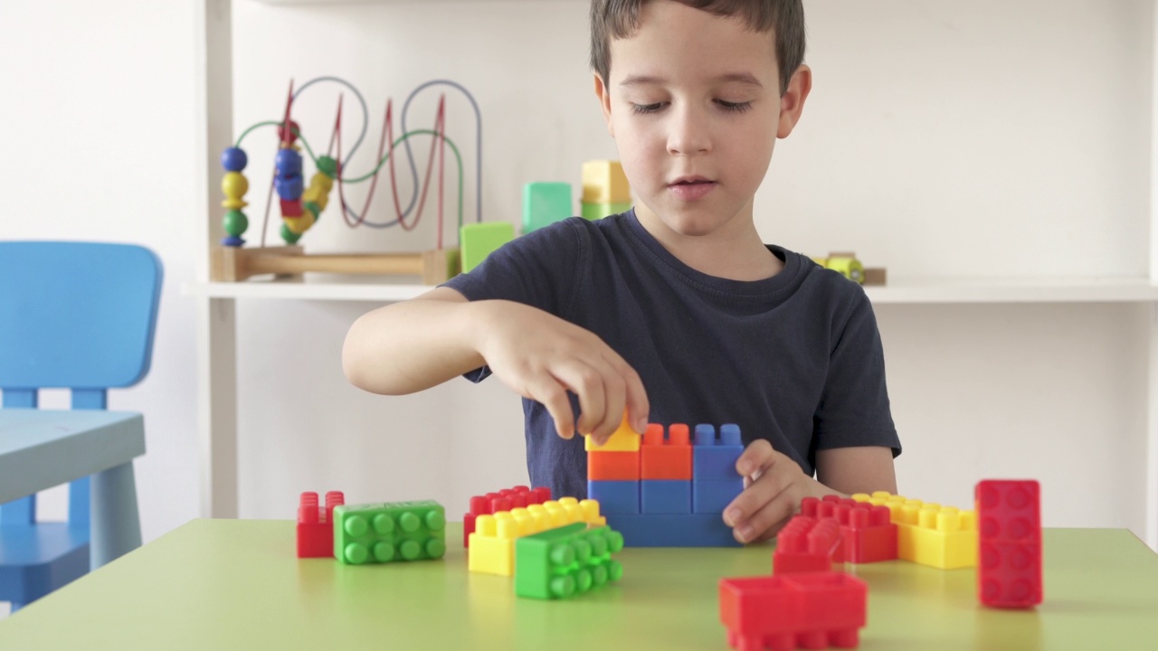 小男孩在玩五颜六色的教育积木视频下载