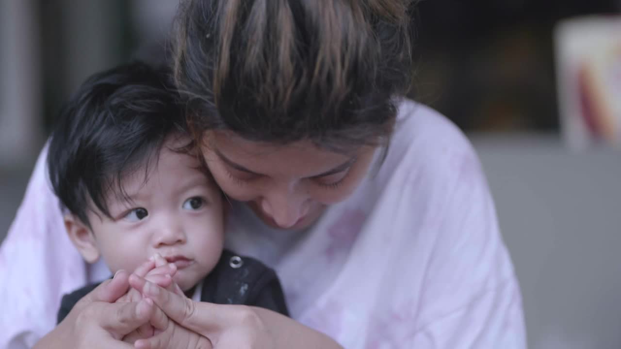 亚洲母亲在家里用勺子喂男婴吃早餐。视频素材