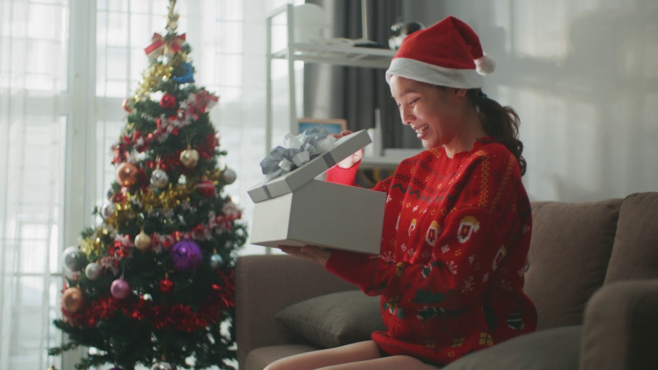 圣诞节，女人打开用红丝带装饰的礼品盒视频素材