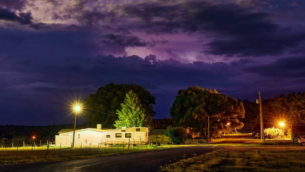 美丽的充满活力的紫色夜空在农村地区。天空中闪着闪电。时间流逝视频素材