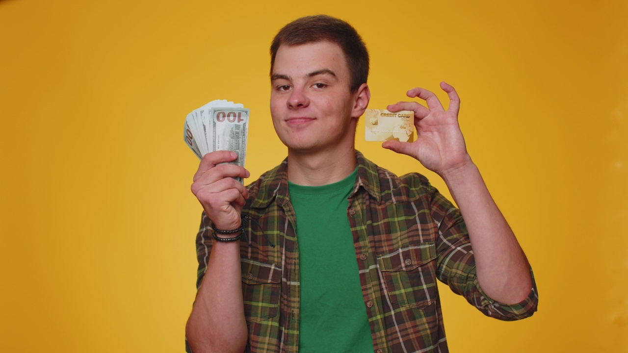 快乐男子展示塑料信用卡银行卡无现金转账广告，网上购物视频素材