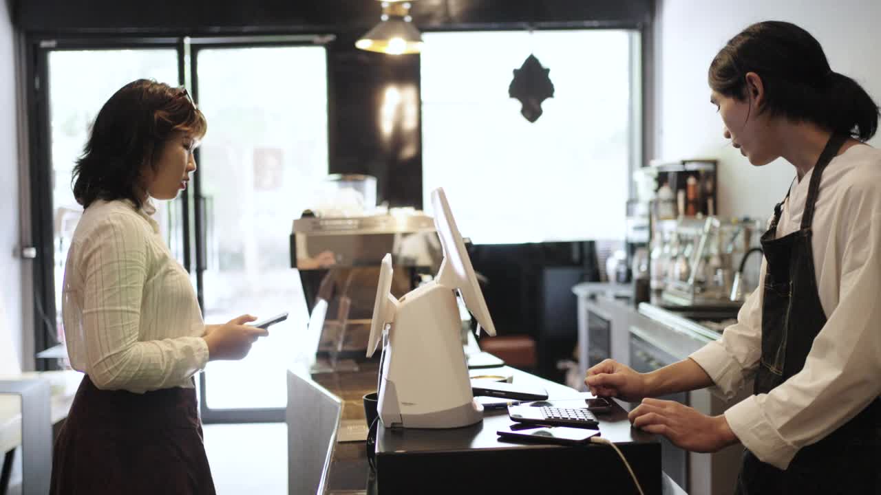 咖啡师在咖啡屋与顾客电话沟通咖啡点单及付款事宜视频下载
