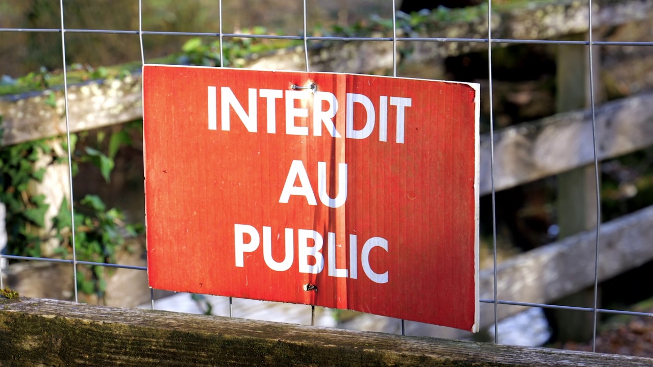 森林里一座木桥的栅栏上用法语写着“禁止公众入内”的标志视频下载