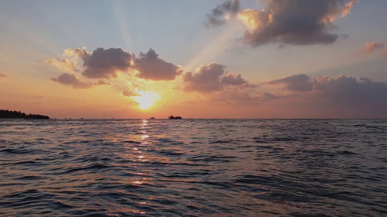 五彩缤纷的橙色日落马尔代夫海从水面pov。锅视频素材