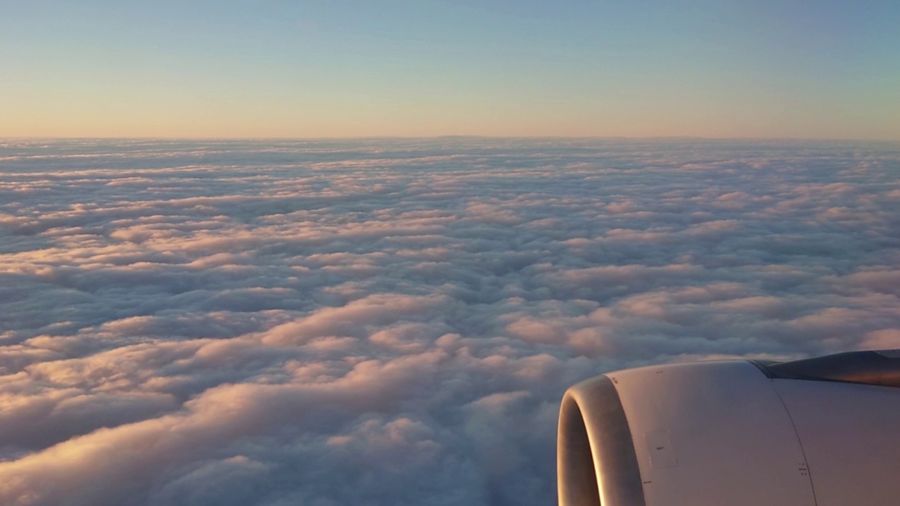 一架A330喷气式飞机从云层上俯瞰的鸟瞰图。其中一个大引擎清晰可见视频素材