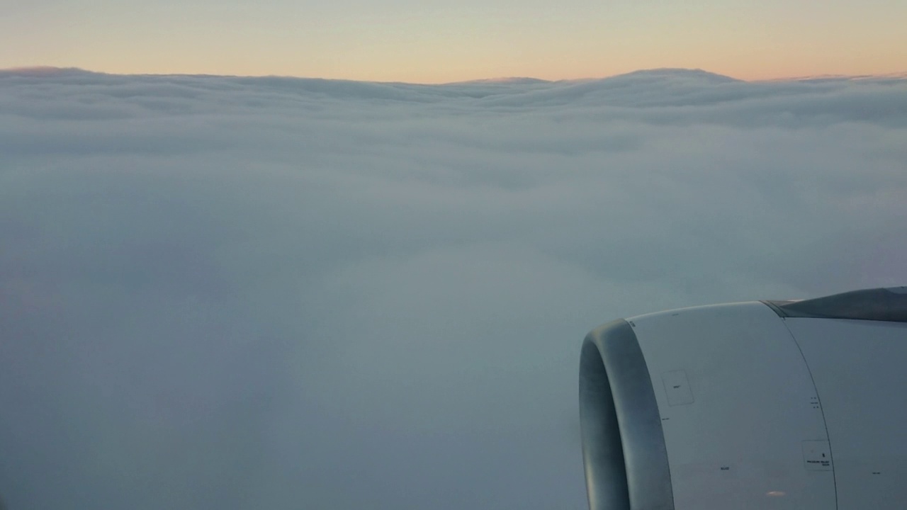 在A330喷气式飞机上从云层上方俯瞰的鸟瞰图。其中一个大引擎清晰可见视频素材