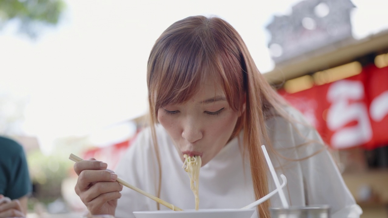 日本长发女子吃拉面(日式蛋面风格)的正面视频素材