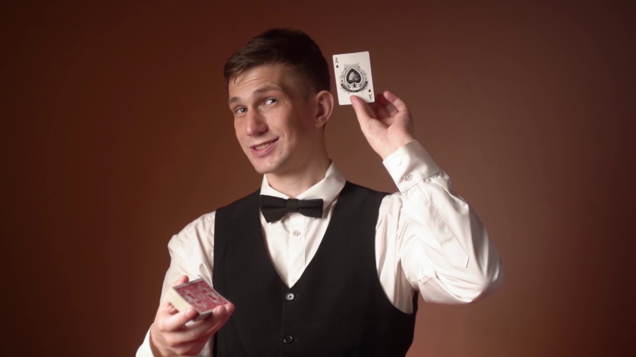 一个年轻的白人男性经销商从一副牌中拿出一张幸运卡的肖像。孤立的视频下载