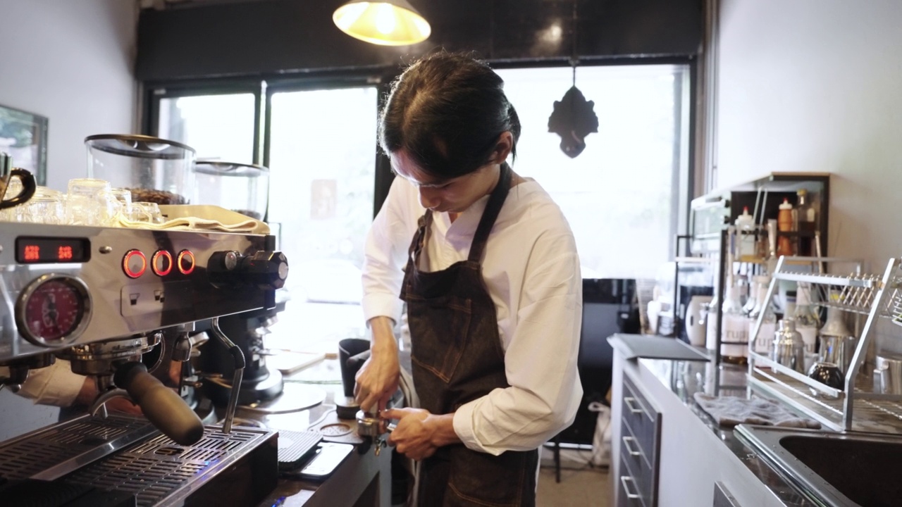 咖啡师在咖啡馆准备咖啡机和冲泡浓缩咖啡视频下载