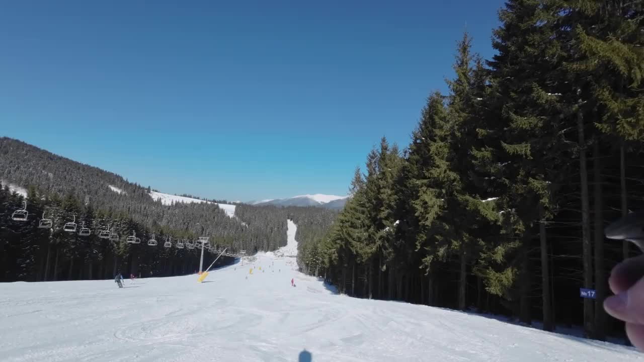 阳光明媚的日子，男人的影子在滑雪场滑雪。观点视频素材