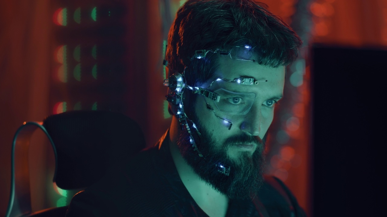黑发男戴着耳机和麦克风，在赛博朋克风格的霓虹灯下工作视频下载