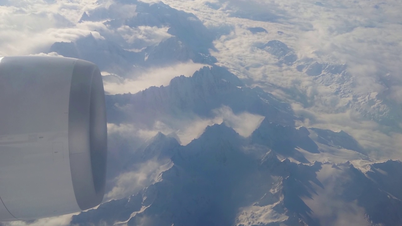 从一架大型喷气式飞机A330上俯瞰瑞士阿尔卑斯山。其中一个引擎清晰可见视频素材
