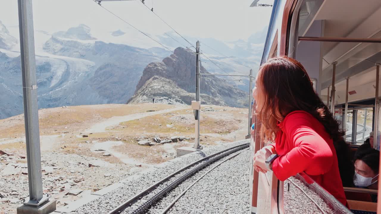 一位亚洲妇女在火车上向窗外望去，自然景观令人惊叹视频素材