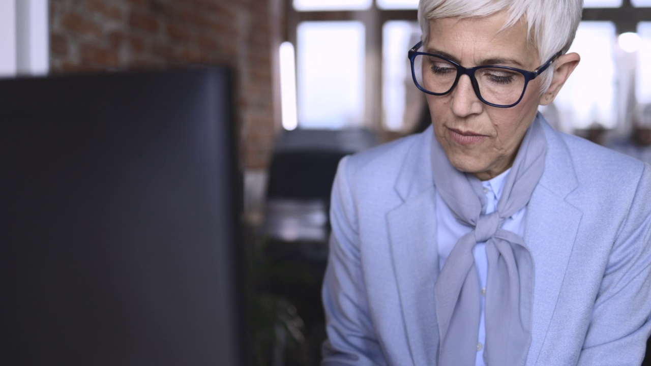 高级商务女性，在办公室使用电脑工作。视频素材