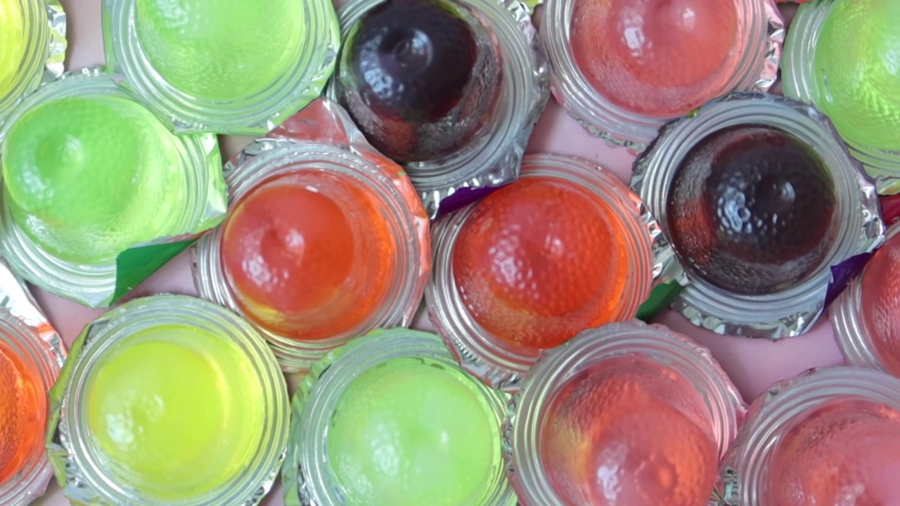 特写彩色果冻在一个塑料容器视频下载