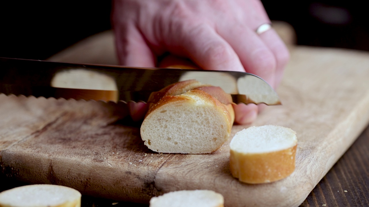 烹饪时将新鲜的脆皮小麦法棍切成小块视频素材