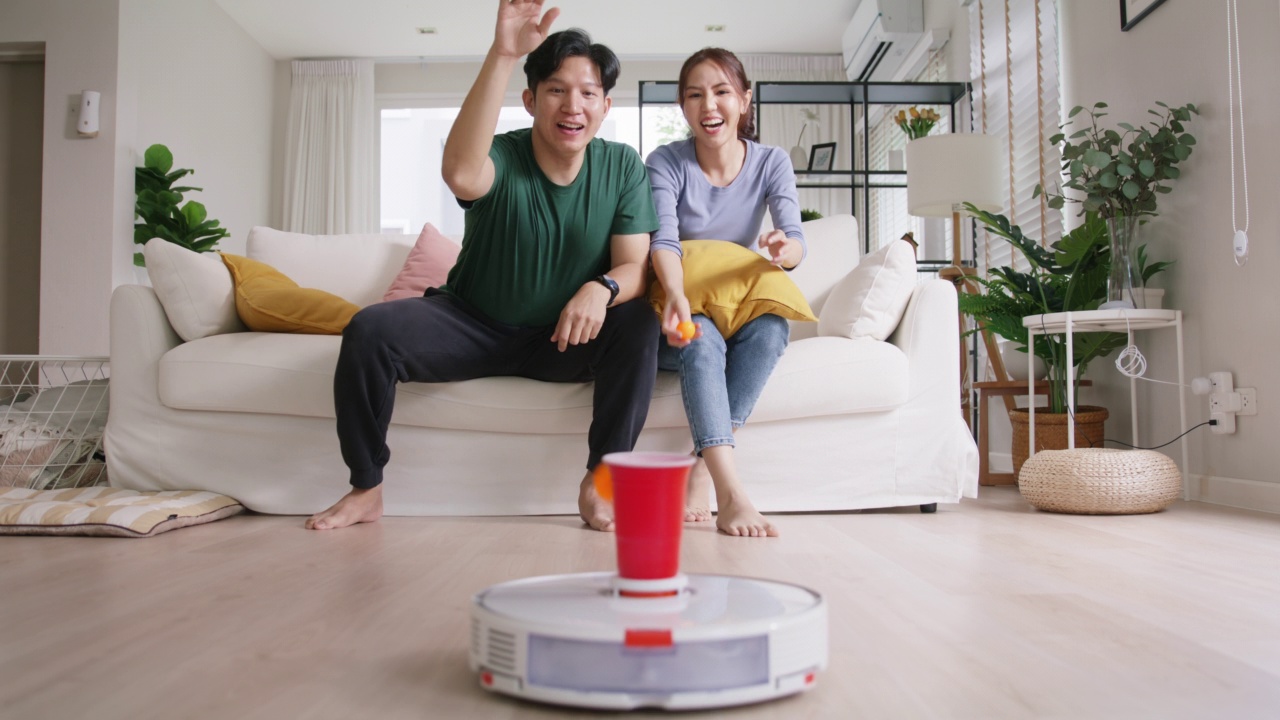 年轻的亚洲夫妇快乐的城市生活方式与物联网在沙发有趣的活动。视频素材
