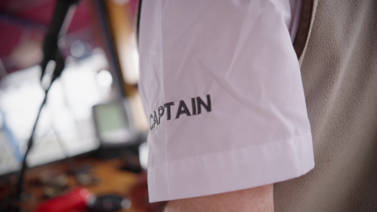 特写镜头的字船长缝到一件白衬衫袖子视频下载