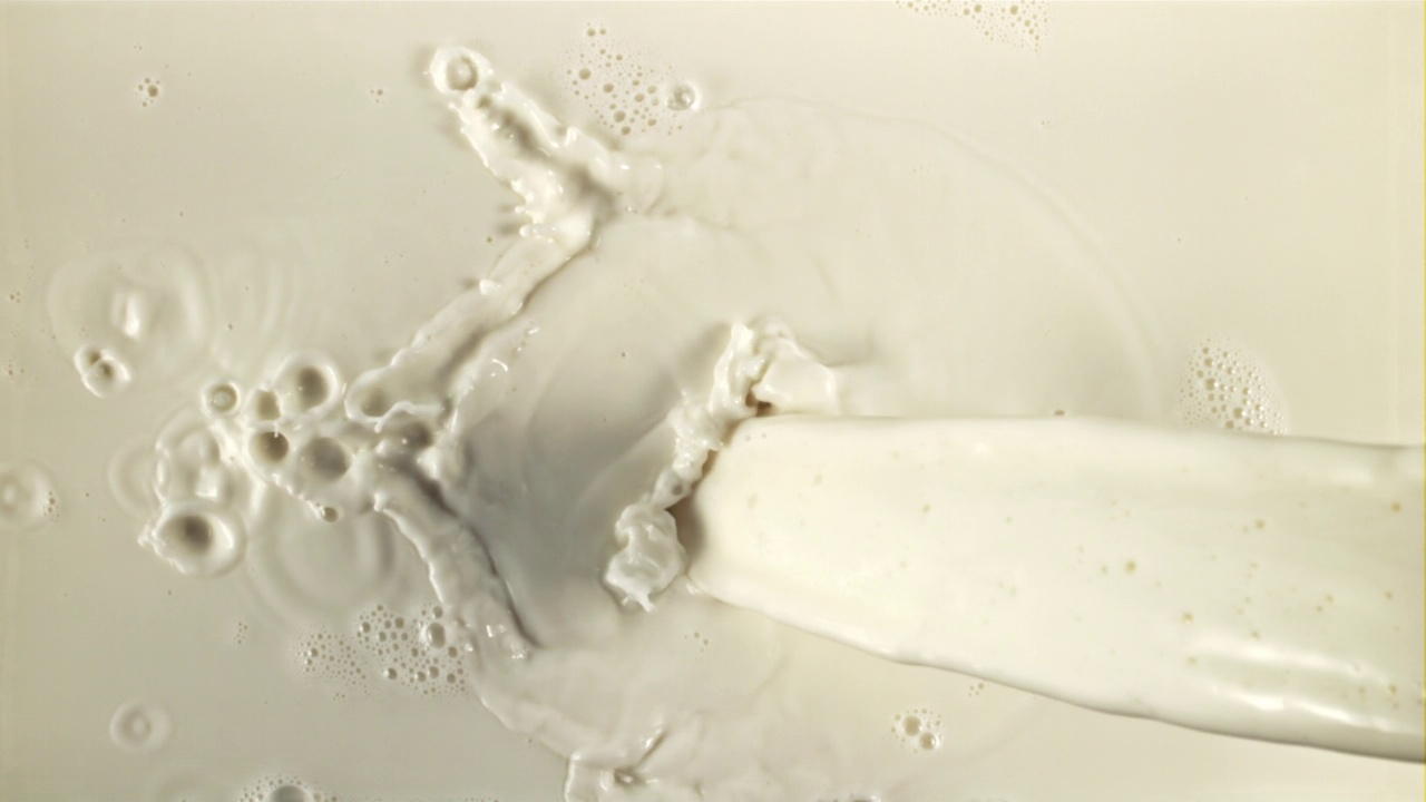 牛奶流着水花和气泡。用高速摄影机以每秒1000帧的速度拍摄。视频下载