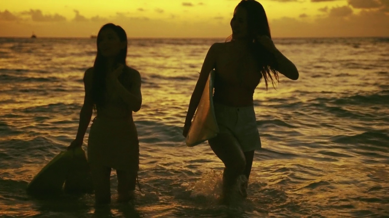 两个亚洲女孩在度假时在海滩上玩得很开心。自由、旅行、冒险的概念。视频购买