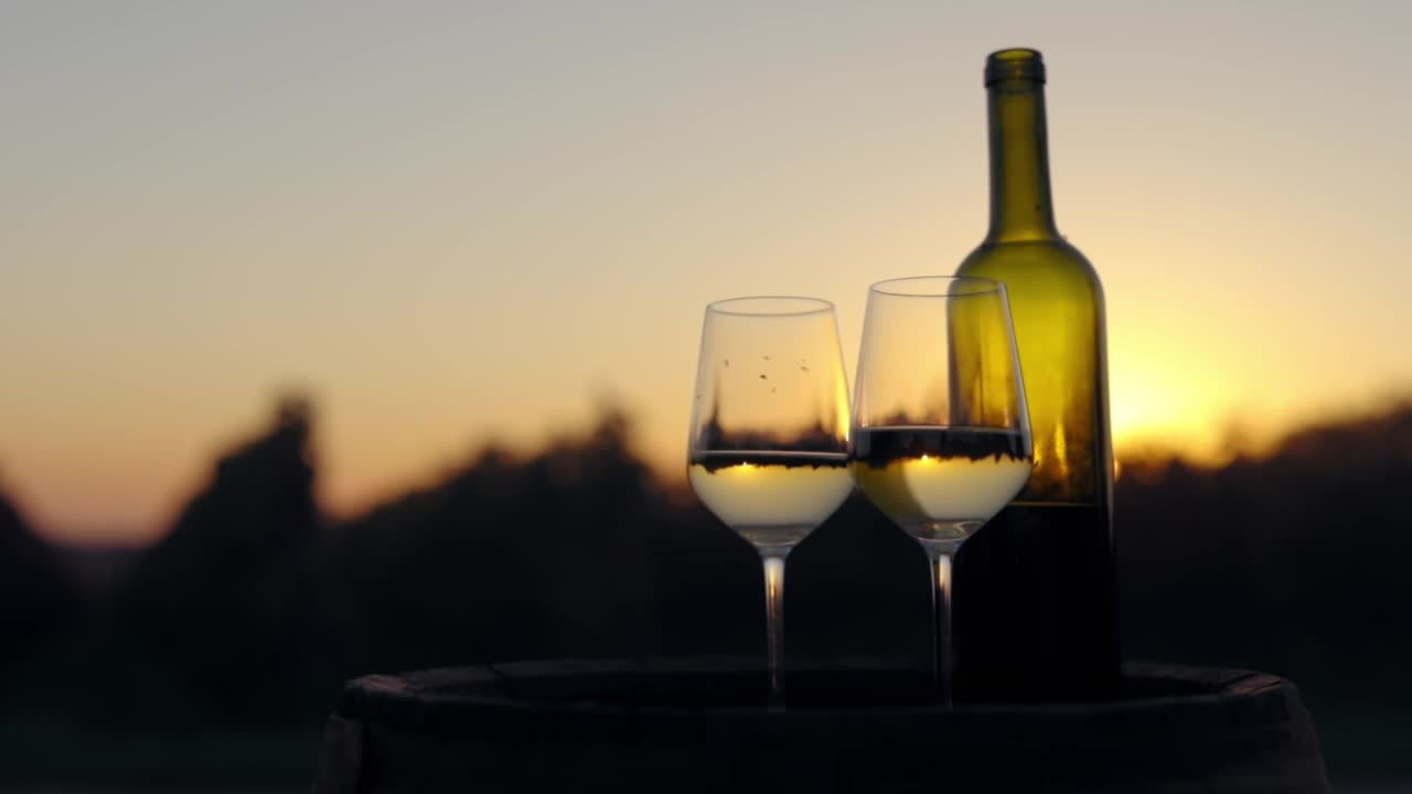 两个玻璃杯和一瓶白葡萄酒装在木桶里视频下载