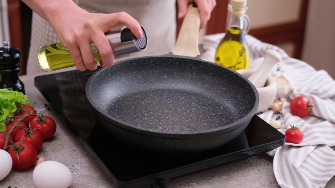 在煎锅上喷洒烹饪橄榄油的妇女视频下载