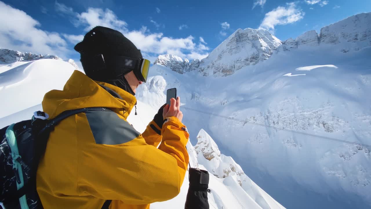 滑雪爱好者在山顶用智能手机拍照视频下载