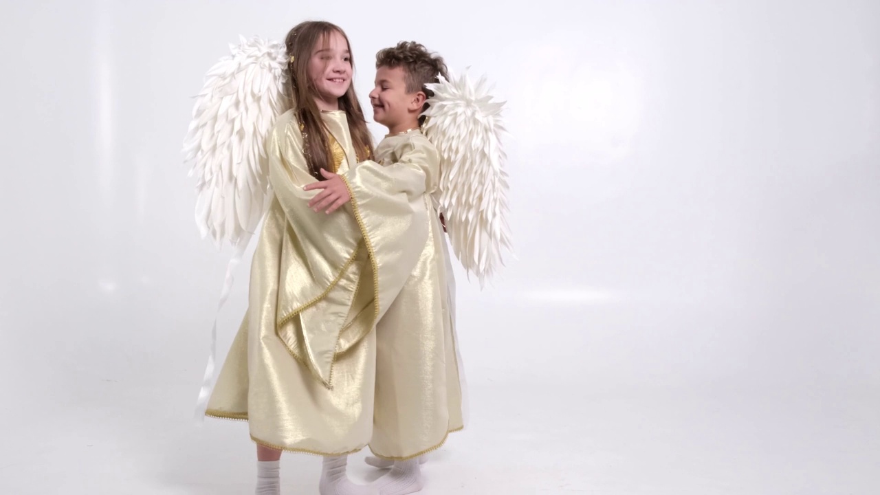 在工作室的白色背景上，长着白色翅膀的儿童天使在工作室里玩耍视频下载