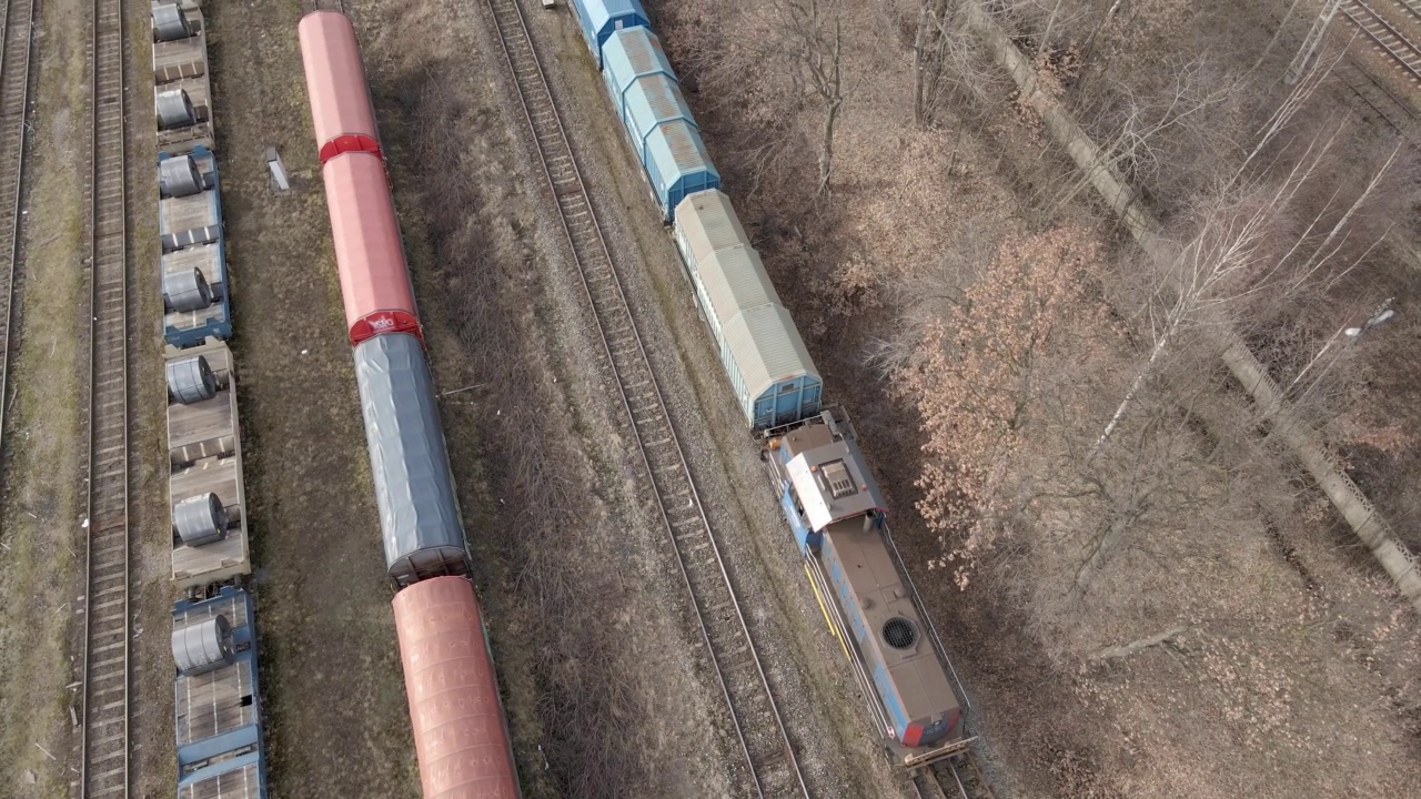 航拍列车减速行驶在其他货运列车之间视频素材