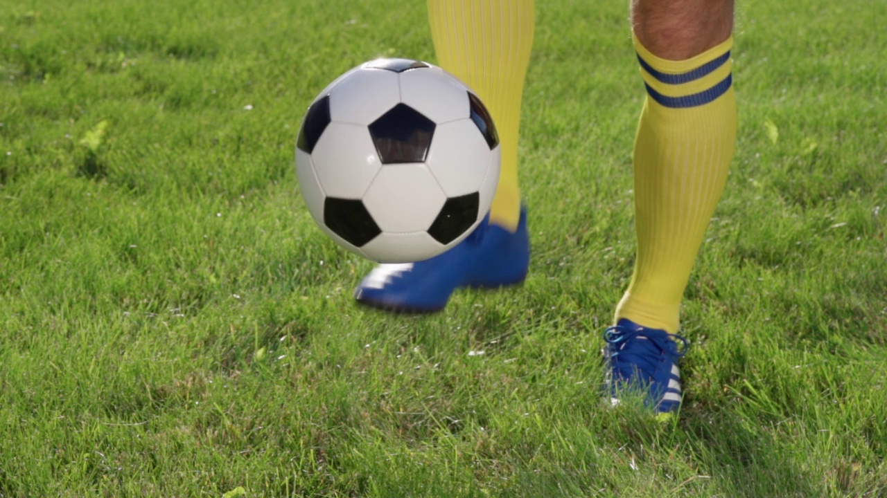 足球运动员用脚踢球。足球运动员训练，慢动作视频下载